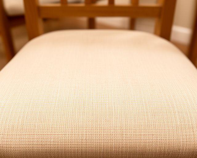 Dining chair seat after stain removal with even beige upholstery and refreshed texture